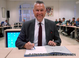 Bürgermeister Stefan Bubeck unterzeichnet den Vertrag im Beisein des Gremiums. 