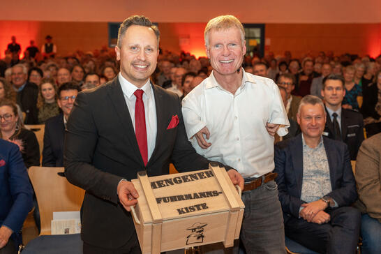Bürgermeister Philip Schwaiger überreicht dem Gastredner Matthias Berg die Fuhrmannskiste